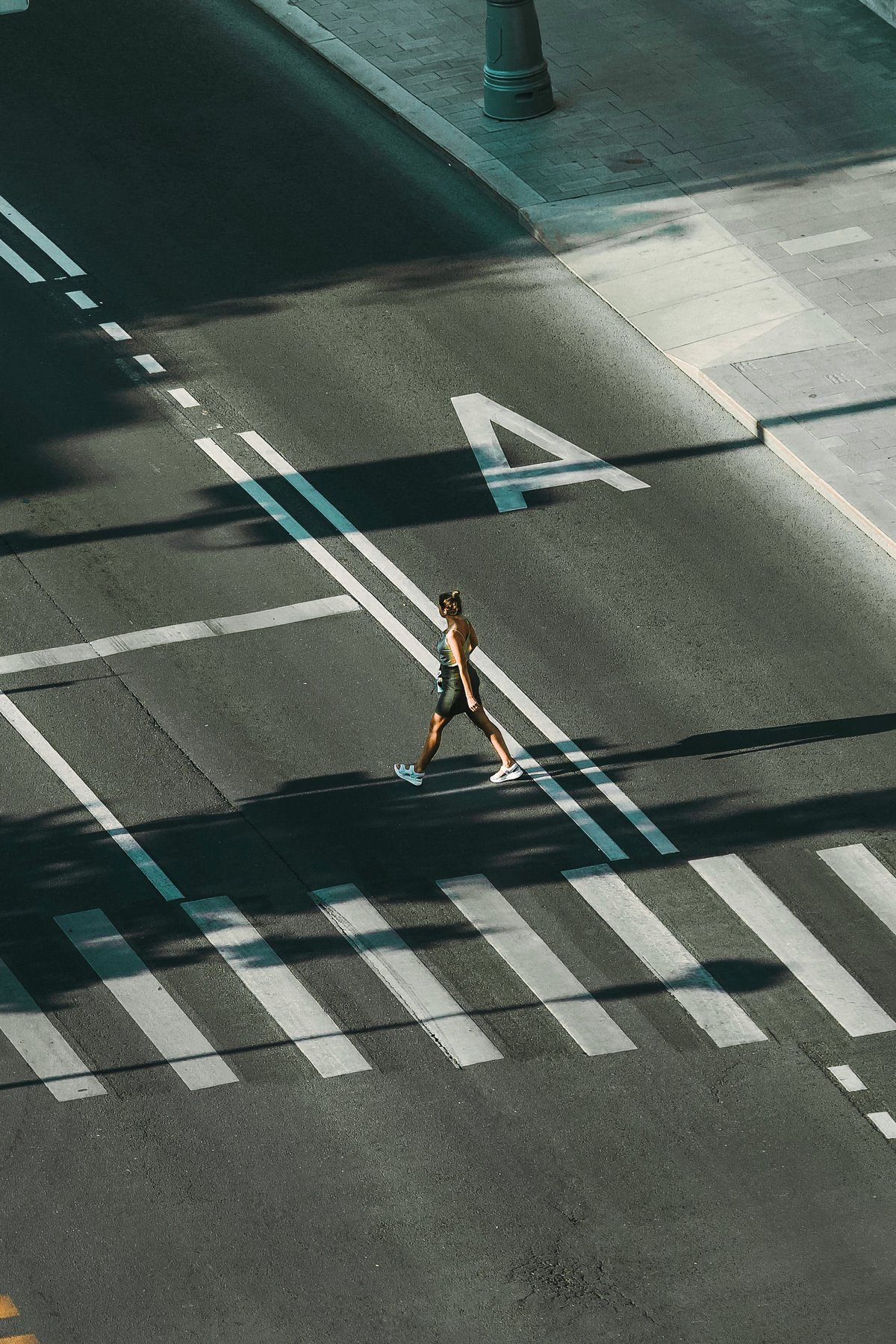 Pedestrian crossing a city intersection viewed from above